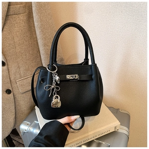 Détail du sac seau en cuir grainé noir avec fermoir en métal argenté et breloques mode