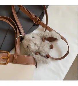 Primo piano di un portachiavi a forma di coniglio in peluche con dettagli in pelle marrone