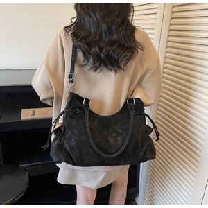 Close-up of black vintage large capacity tote bag with drawstring side detail and dual straps