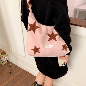 Detail of pink crossbody bag with brown plush stars and unique knotted shoulder strap