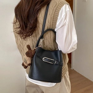 Détail du sac seau en cuir grainé noir avec boucle argentée et charm lapin mignon