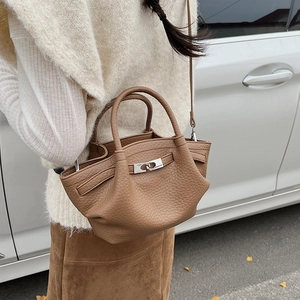 Détail d'un sac seau en cuir grainé avec fermoir argenté et bandoulière réglable