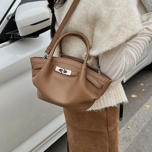 Détail macro du sac en cuir marron grainé avec fermoir rotatif argenté en extérieur