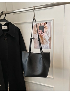 Detailed close-up of black lychee grain texture on a spacious tote bag for women
