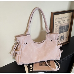 Close-up of large pink tote bag with drawstring side detail and silver metal hardware