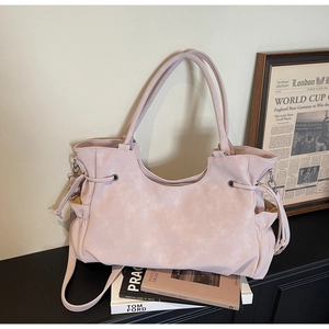 Detailed view of pink tote bag with side drawstring texture and adjustable strap