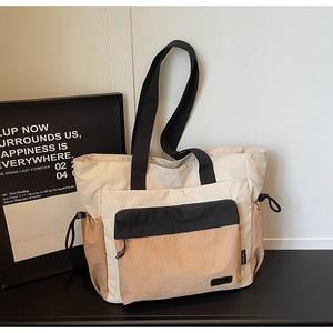 Detail view of contrast color tote bag with front zipper pocket and drawstring sides
