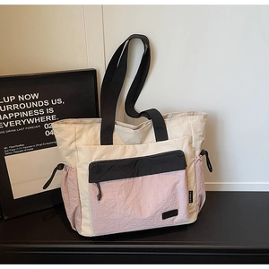Detail of multi-color tote bag with drawstring side and durable nylon texture