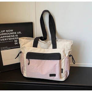 Detail of multi-color tote bag with front flap pocket and dual nylon handles
