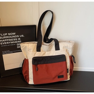 Macro view of color-block canvas tote bag with nylon textures and modern brand tag