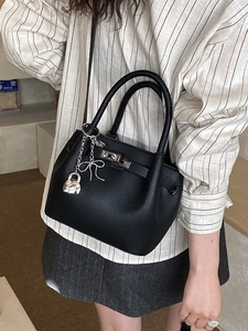 Sac seau rétro noir en cuir grainé avec fermoir argenté et breloque noeud papillon
