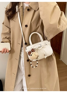 Weiße Mini-Tasche mit Schleife und Bärenanhänger, präsentiert am Modell im Streetstyle