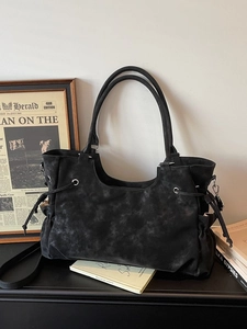 Retro black matte tote bag with drawstring detail shown in an artistic lifestyle setting