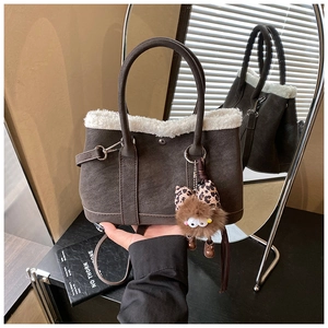 Détail du sac cabas marron mat avec bordure en peau lainée et breloque nœud léopard