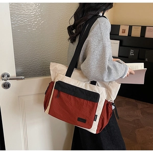 Close-up of tricolor tote bag with contrast panels and functional side drawstring details
