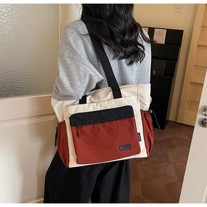 Detail of color-block nylon tote bag with wide strap and side drawstring pockets