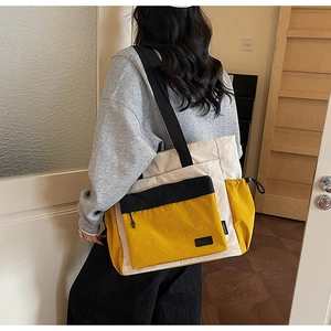 Detail of tricolor tote bag showing yellow and beige panels with drawstring side pocket