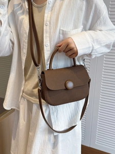 Bolso bandolera marrón texturizado con hebilla circular y correa ajustable para mujer