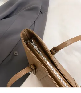 Detail of silver zipper and lychee grain leather on a vintage brown tote bag