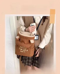 Close-up of brown sherpa fleece backpack with cute 3D ears and embroidered letter details