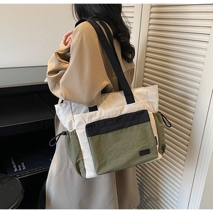 Lifestyle shot of large capacity color-block tote bag in olive green and beige nylon