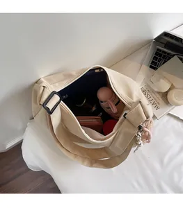 Detail view showing large storage capacity of a beige canvas tote with interior essentials