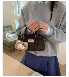 Detail of dark coffee velvet Boston bag with BAI MIAO ER tag and plush bear charm