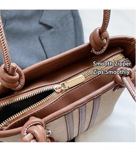 Close-up of the smooth gold metal zipper and leather trim on this stylish bucket bag