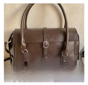 Gros plan sur la boucle et les accessoires argentés d'un sac cabas vintage marron foncé