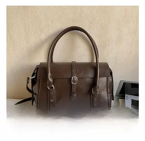 Détail de la texture en similicuir poli et de la boucle en métal vintage sur le sac cabas