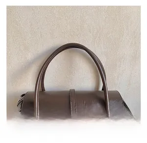 Vue détaillée de la poignée du sac fourre-tout en cuir marron et zip métallique