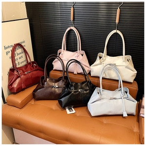 Detailed display of six stylish gathered tote bags in various colors on a leather bench