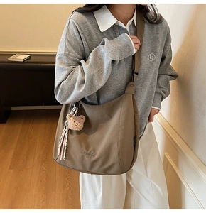 Brown canvas tote bag with Midoluu embroidery and a cute plush bear charm detail