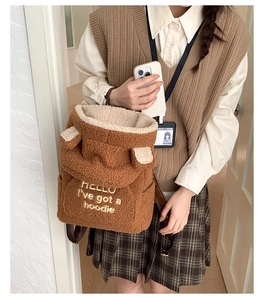 Detailed texture of brown plush fuzzy backpack with cute 3D ears and embroidery detail