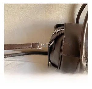 Détail du crochet en métal argenté et coutures en cuir sur le sac cabas marron foncé