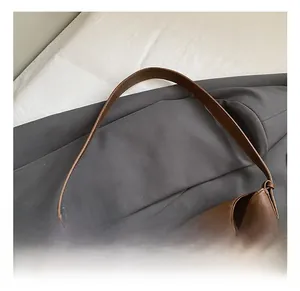 Detail view of large brown oil wax leather tote bag with metal twist lock closure