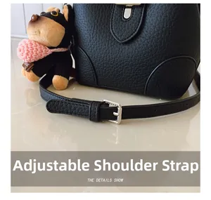 Detail showing adjustable strap with silver buckle on black pebbled leather bucket bag