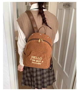 Rear view of brown plush faux shearling backpack with embroidery for casual school travel