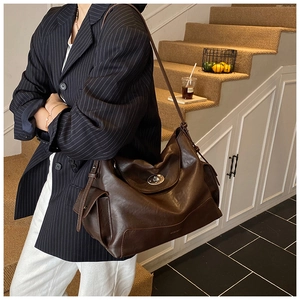 Detail of vintage dark brown leather tote featuring a signature silver metal twist lock