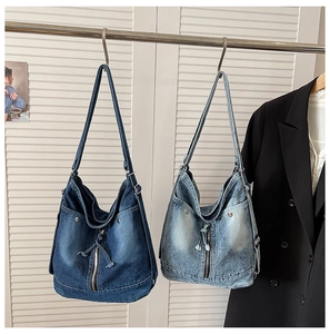 Détail de cabas en denim bleu clair et foncé avec fermetures à cordon et rivets