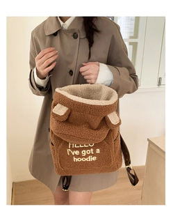 Detail of soft brown teddy fleece backpack featuring white HELLO embroidery and cute ears