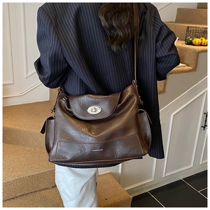 Detail of vintage dark brown faux leather tote with metal twist lock and side pocket