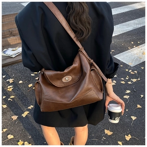 Deep brown leather tote bag with vintage gold twist lock shown in a casual street setting