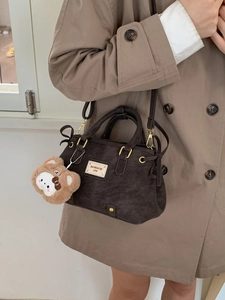 Fashionable dark brown matte top handle bag with teddy bear charm and adjustable strap