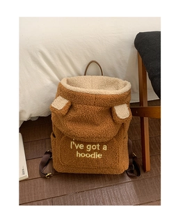 Detail of plush teddy fleece backpack with ear accents and embroidered text