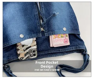Détail de la poche avant sur sac en jean bleu avec boutons-pression métalliques