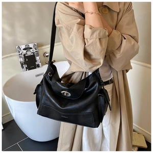 Detail of black tote bag with silver twist lock and side pocket on textured leather