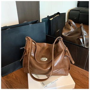 Detailed shot of brown vintage hobo tote bag with silver metal swivel lock and soft leather