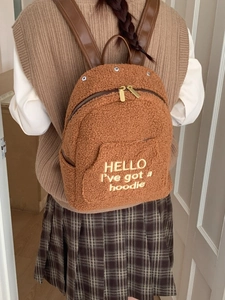Brown teddy fleece backpack for women featuring white embroidery and leather straps