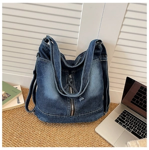 Detail der blauen Jeans-Tasche mit Vintage-Waschung und Metall-Reißverschlüssen